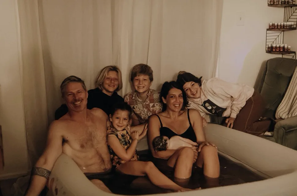 Jenn Miller and her family together in the birth pool with the new baby