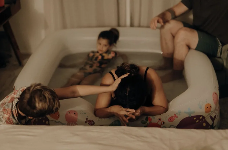 Jenn Miller laboring in the birth pool at home with her children close by