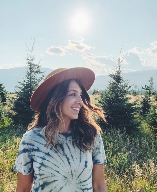 Jenn Miller smiling outdoors in a wide-brimmed hat